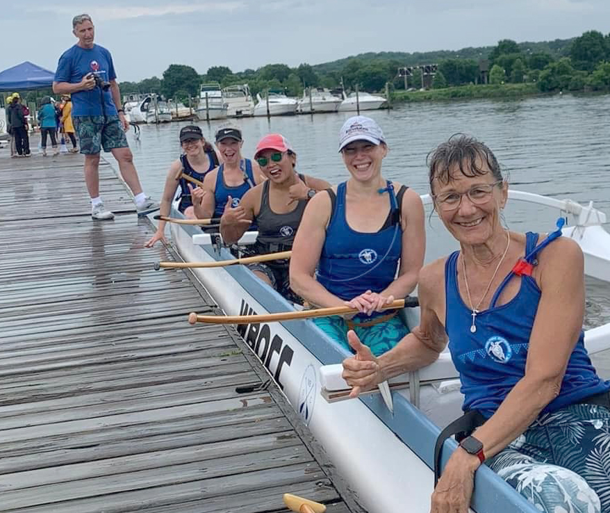 Photo of people sitting in a canoe next to a dock