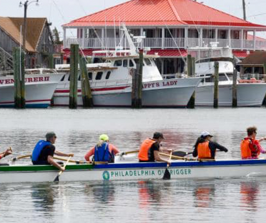 Photo of people paddling a canoe hear a dock